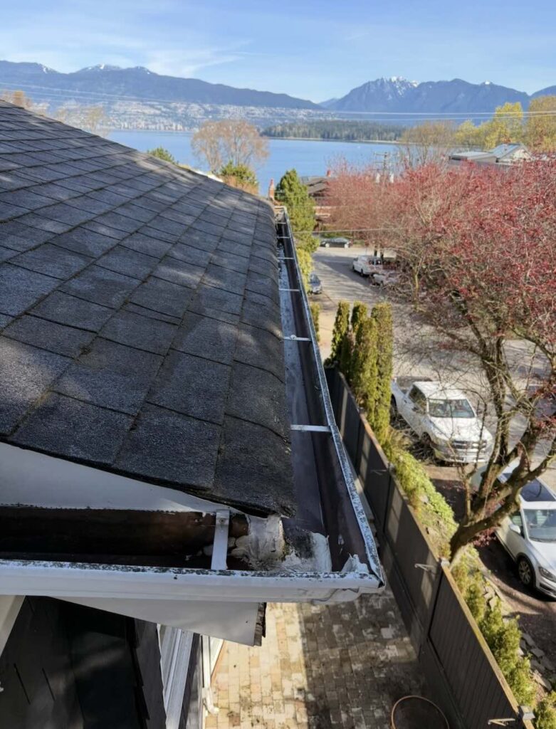 Freshly cleared gutter and downspout on a two-storey home in Surrey