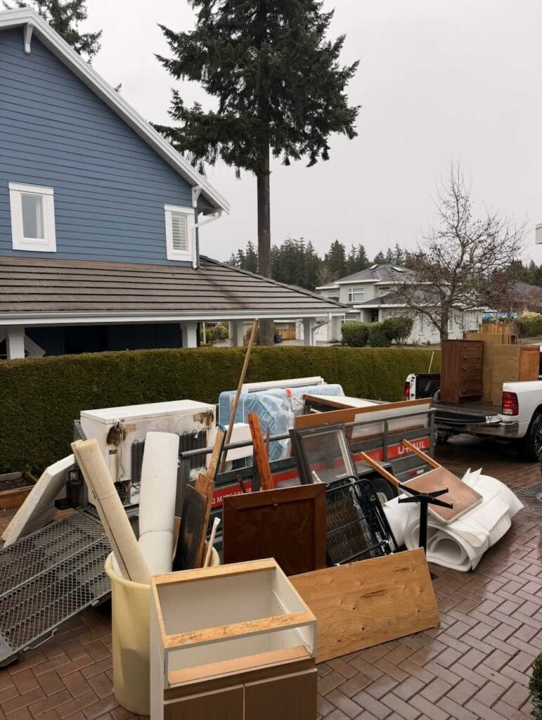 Old furniture, appliances and renovation debris loaded for junk removal outside a home in South Surrey